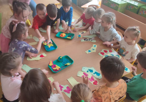 Przedszkolaki z grupy czwartej stemplują farbami szablony skarpet