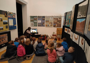 Dzieci siedzą w muzeum i oglądają prezentację o Egipcie