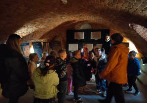 Dzieci w podziemiach zamku oglądają wystawę o Egipcie