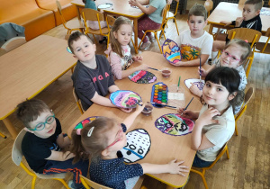 Dzieci z grupy piątej ozdabiają farbami papierowe pisanki