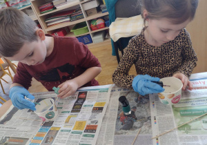 Dwoje dzieci z grupy piątej podczas malowania jajek
