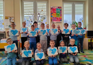 Dzieci z grupy piątej pokazują swoje niebieskie serca