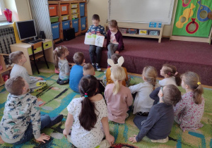 Chłopiec pokazuje obrazek z czytanki dzieciom z grupy piątej