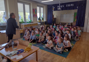 Dzieci słuchają wiersza mówionego przez pana Eugeniusza