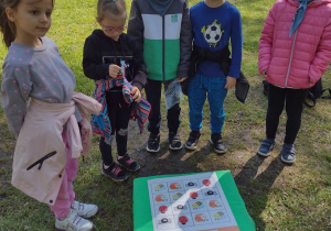 Piątka dzieci stoi przy rozwiązanym sudoku