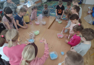 Dzieci nasypują piasek do świeczek