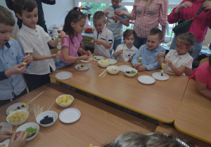 Przedszkolaki podczas nabijania owoców na szaszłyki