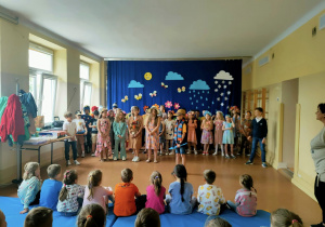Dzieci oglądają dzieci z klas drugich podczas przedstawienia