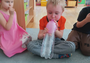 Chłopiec dmucha balon umieszczony w butelce