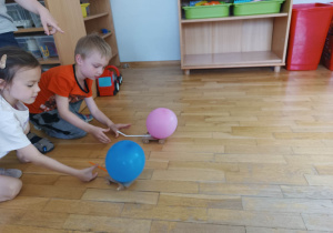 Dwoje dzieci szykuje swoje balony do wyścigu