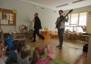 dzieci uczestniczą w audycji muzycznej - gra na gitarze elektrycznej