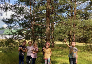 Dzieci stoją przy drzewie
