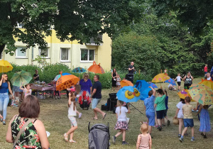 Dzieci z rodzicami podczas tańca z parasolkami