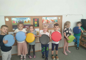 Siedmioro dzieci z grupy III stoi z okrągłymi pufami