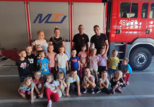 Dzieci stoją przy wozie strażackim