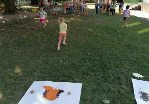 Dzieci biegną z kolorowym lisktiem, aby przykryć rysunkowego jeżyka