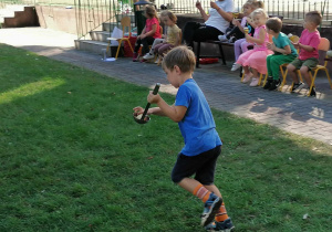 Chłopiec biegnie z jabłkiem na łyżce wazowej