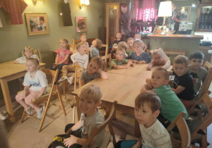Przedszkolaki z grupy III siedzą przy stolikach podczas przedstawienia