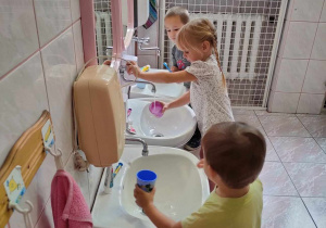 Troje dzieci myje ząbki