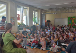 Dzieci obserwują jak chłopiec próbuje dyrygować instrumentalistami