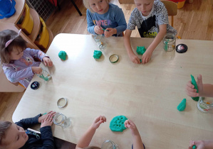 Szóstka dzieci robi plastelinowe ogórki