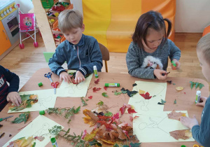 Pięcioro dzieci przykleja liście na szablon sukienki