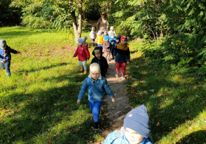 Dzieci idą wąską ścieżką w parku
