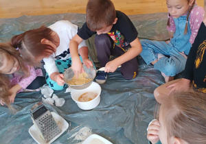 Dzieci odciskają starte ziemniaki na sitku
