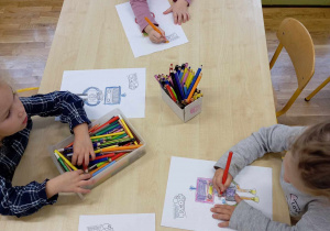 Czworo dzieci z grupy II koloruje obrazek z robotem