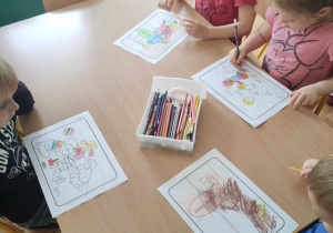 Czworo dzieci z grupy III koloruje obrazek o dobrym zachowaniu