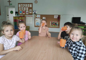 Piątka dzieci pije sok z marchewki