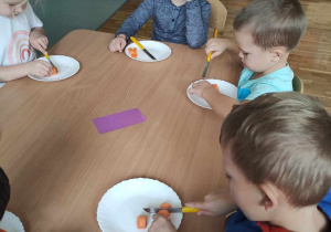 Dzieci kroją ugotowaną marchewkę