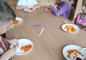 Dzieci kroją marchewkę w plasterki