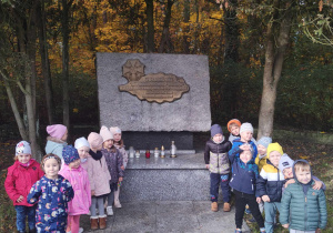 Dzieci z grupy II przy pomniku w parku