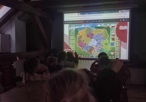 Przedszkolaki oglądają aktulaną mapę Polski z podziałem na województwa