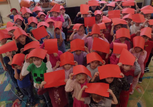 Dzieci ustawione są w kształcie serca z czerwonymi kartkami uniesionymi w górze