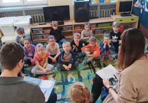 Dzieci słuchają opowiadania czytanego przez rodziców Martynki