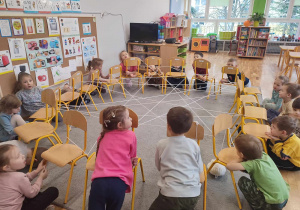 Przedszkolaki z grupy III siedzą przy utkanej pajęczynie ze sznurka
