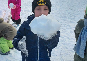 Chłopiec z wielką kulką ze śniegu
