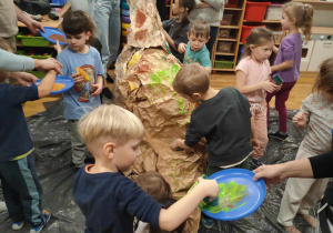 Dzieci podczas malowania dinozaura