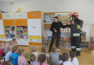 wizyta strażaków w przedszkolu - demonstrowanie jak działa maska zabezpieczająca przed dymem