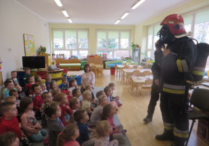 wizyta strażaków w przedszkolu - demonstrowanie jak działa maska zabezpieczająca przed dymem