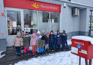 Przedszkolaki stoją przed pocztą