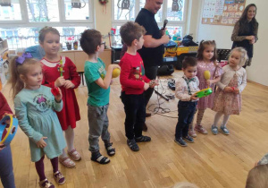 Ośmioro dzieci gra na instrumentach perkusyjnych do świątecznej piosenki
