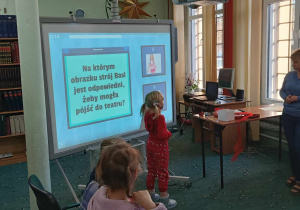Dziewczynka rozwiązuje zadanie na tablicy multimedialnej
