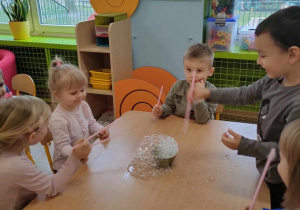 Dzieci robią bańki przez słomki