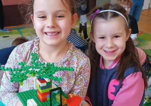 Dwie dziewczynki z budowlą z klocków lego
