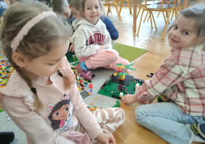 Trzy dziewczynki budują z klocków lego