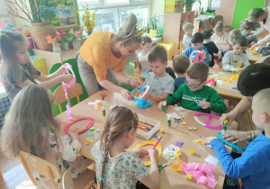 Dzieci owijają szablony pisanek bibułą