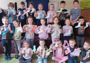 Dzieci z grupy piątej pokazują swoje pokolorowane szablony skarpet